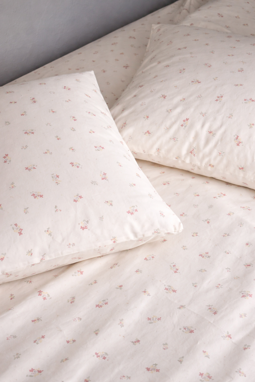 Floral-patterned bedding set with two pillows on a plain background