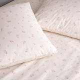 Floral-patterned bedding set with two pillows on a plain background